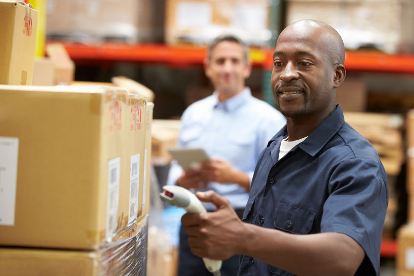 man working at a warehouse scanning bar-codes on boxes