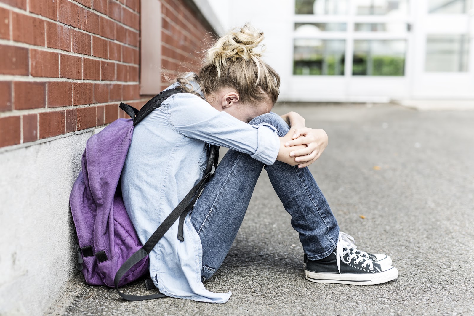 school aged hugging her legs girl alone crying 