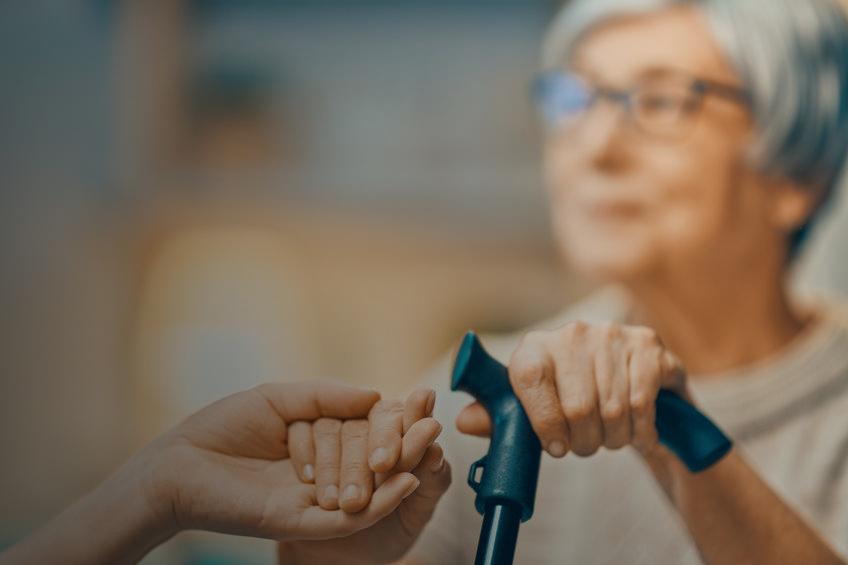older female adult reaching for assisting hand