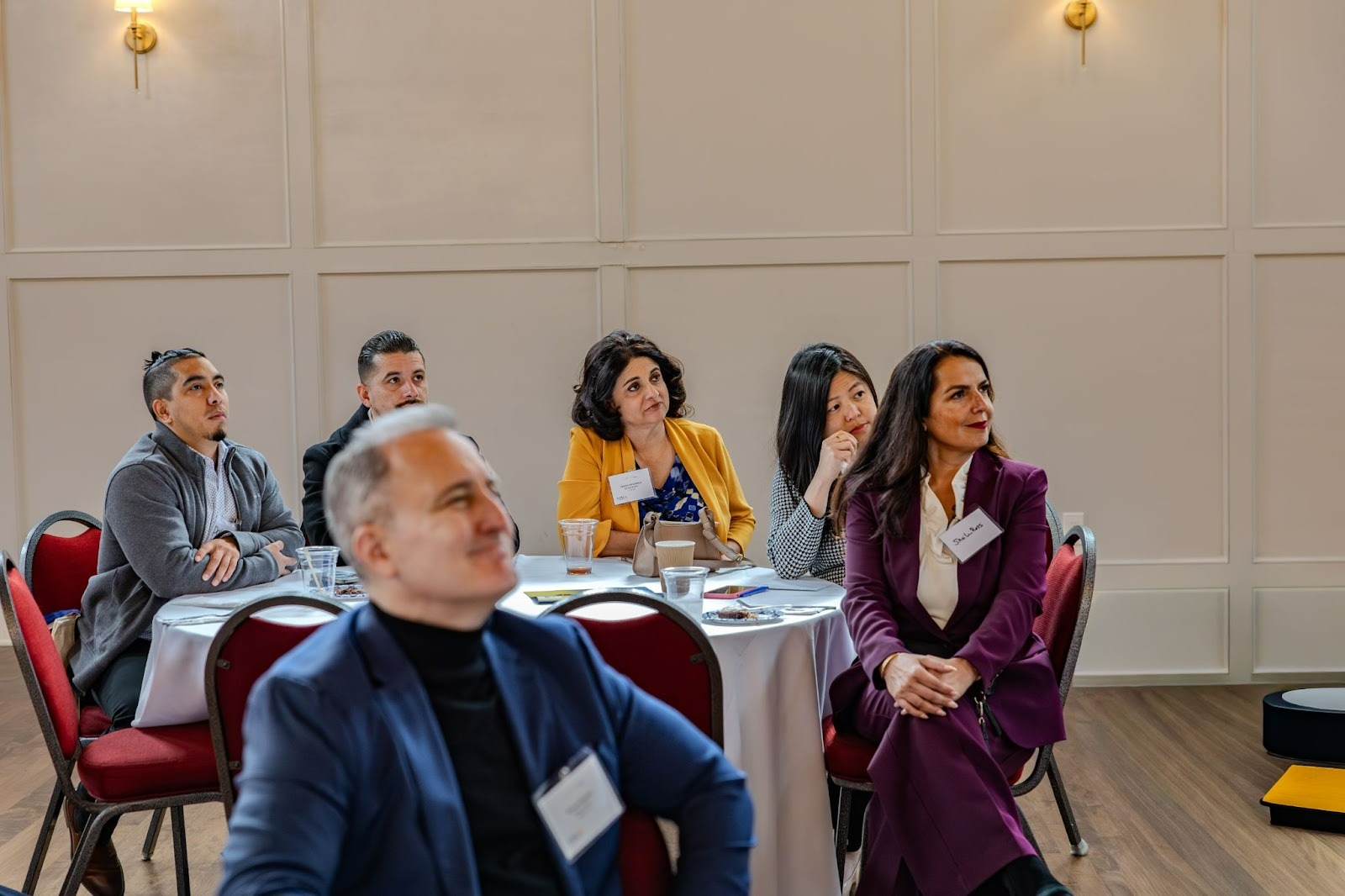 Several Attendees smiling as they listen during the event