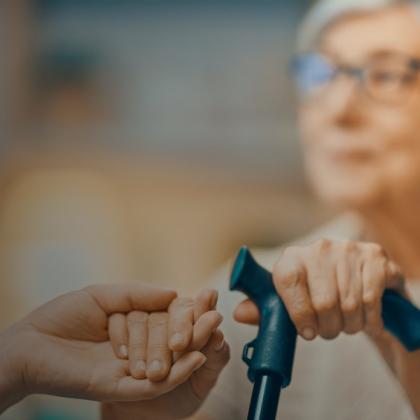 Senior woman with cane having hand held representing senior care