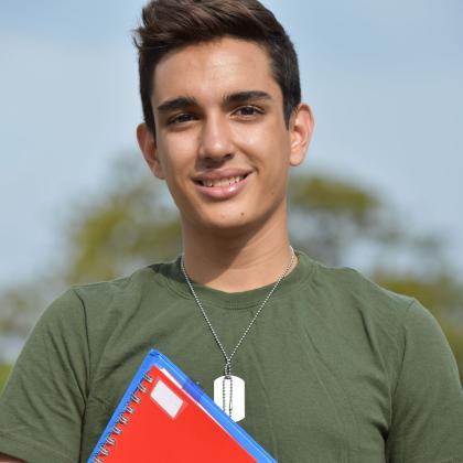 Youth wearing dog tags holding school books