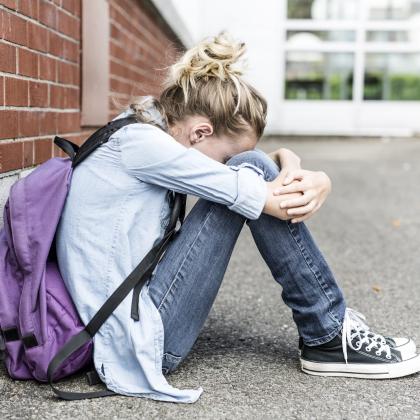 school aged hugging her legs girl alone crying 