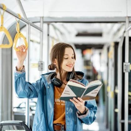young woman reading on public transportation