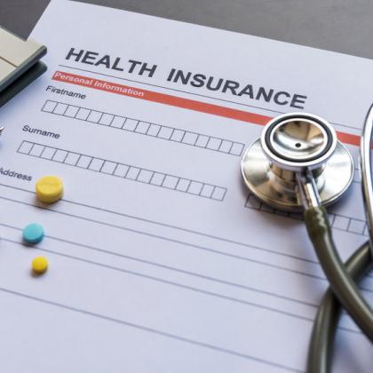Health insurance forms, stethoscope, pills and calculator
