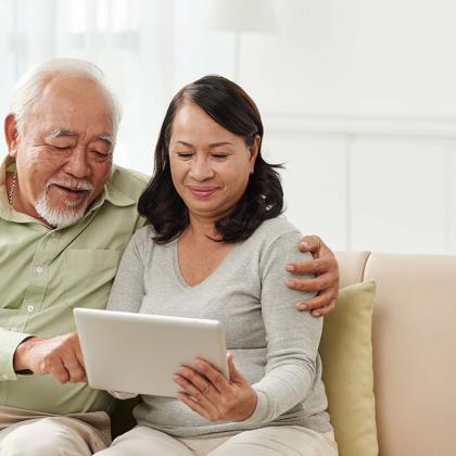 two adults looking at a tablet