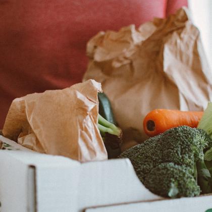 Individual holding groceries in a box