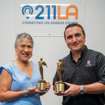Maribel Marin on the left, wearing blue shirt and white pants. Art Simon on the right wearing black button up and black pants