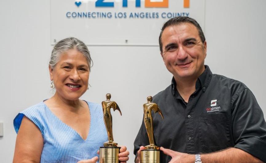 Maribel Marin on the left, wearing blue shirt and white pants. Art Simon on the right wearing black button up and black pants