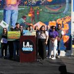 LA vs Hate podium, with Manager Anthony Perez from LA vs Hate on the Left holding green sign