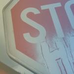 stop sign with the words hate under the word stop. indicating "Stop Hate" with a blue and yellow translucent color over the image 