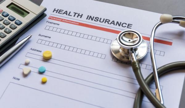 Health insurance forms, stethoscope, pills and calculator