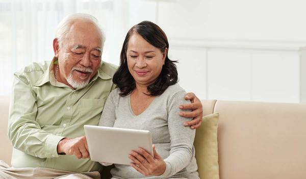 two adults looking at a tablet 